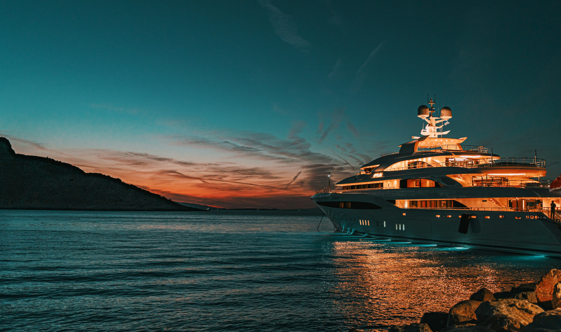 A luxury yacht on the water at sunset